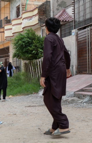 Children play on a street as health workers visit a house during door-to-door polio vaccinations in a community in Islamabad, Pakistan.